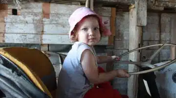 girl in gray tank top and pink bucket hat sitting on chair