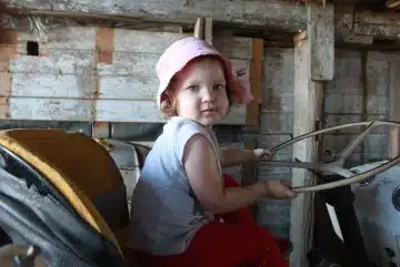 girl in gray tank top and pink bucket hat sitting on chair