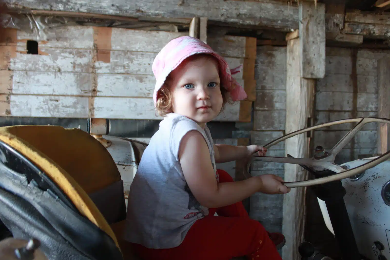 girl in gray tank top and pink bucket hat sitting on chair